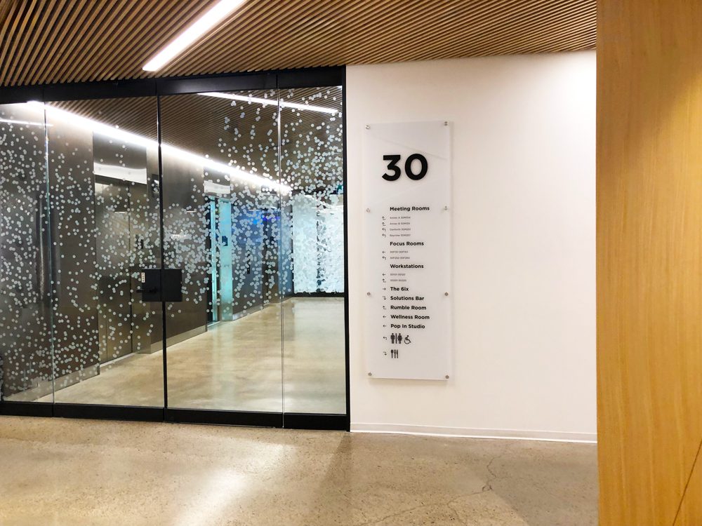 Directory and room identification wayfinding sign panel in a Seattle office corridor