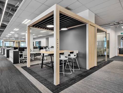 Semi-open workplace pod with wood framing and integrated seating at the ZEISS Innovation Center